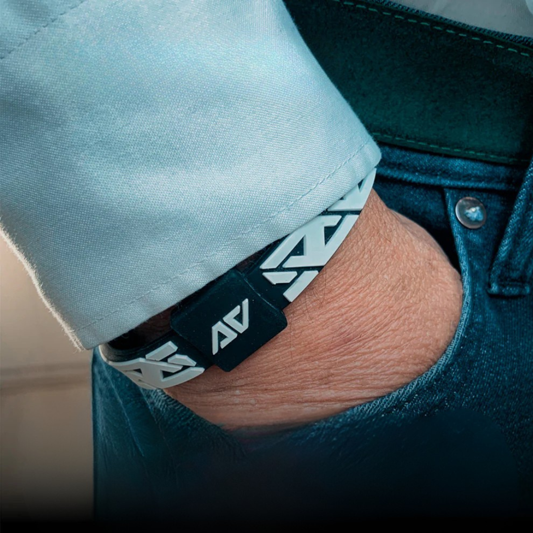 AV Edge polsband in zwart/wit gedragen om de pols, hand in de broekzak